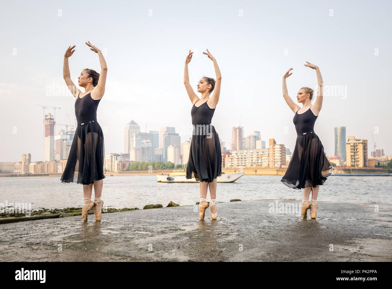 Londres, Royaume-Uni. 20 Juin, 2018. Danseurs de Ballet Company de sémaphore effectuer par la Tamise à Deptford quai avec Canary Wharf business park bâtiments dans l'arrière-plan. (L-R) Natsuki Uemura, Rebecca Olarescu et Beth Wareing sont chorégraphiées par sémaphore Ballet Company fondateur et directeur artistique : Maisie Alexandra Byers. Crédit : Guy Josse/Alamy Live News Banque D'Images