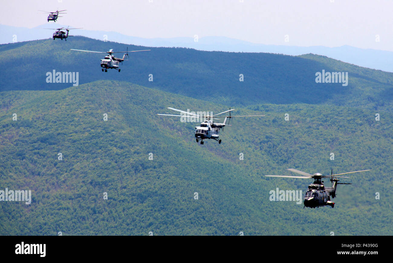 Une force multinationale de plusieurs bâtiments formation d'hélicoptères hélicoptères voler au-dessus du Kosovo, au cours de l'opération Icarus, le 8 juin 2016. La formation comprenait un hélicoptère MI-171, un suisse comme-332 Super Puma de l'armée américaine et l'UH-60 Black Hawk. (U.S. Le personnel de l'Armée Photo : Sgt. Marco Lechuga, 2e Bataillon d'hélicoptères d'assaut, 285e Régiment d'Aviation) Banque D'Images