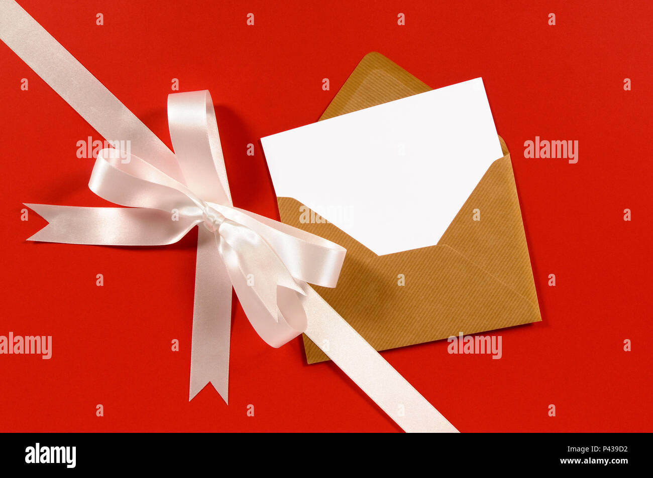 Ruban cadeau blanc bow et sur papier rouge diagonale arrière-plan avec  enveloppe brune et carte vierge Photo Stock - Alamy