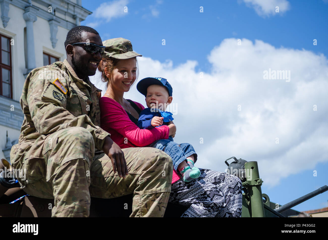Un soldat de l'armée américaine sourit avec une femme polonaise et son fils pour une séance de photos durant une journée du multiculturalisme à Chelmno, en Pologne, le 11 juin 2016. Les forces multinationales ont tenu une exposition de véhicules militaires et d'engins dans la place de la ville dans le cadre de l'exercice Anakonda 2016. L'exercice est dirigée par la Pologne une convention collective de l'effort de formation pour renforcer l'interopérabilité et de renforcer les liens entre les pays alliés et partenaires, assurer la paix et la sécurité collective dans la région. Banque D'Images
