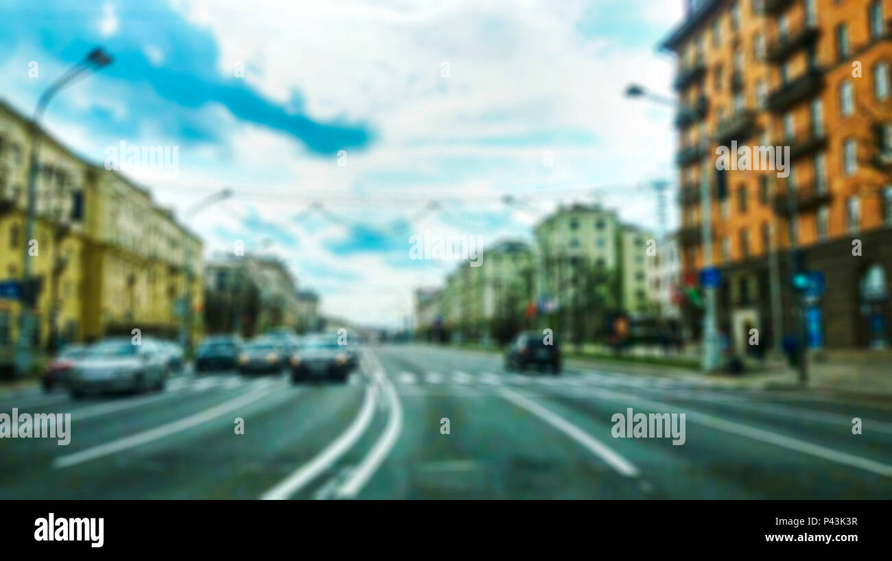 Avenue urbain avec des véhicules en mouvement dans une histoire avec une image de surface floue. Voir à travers le pare-brise de la voiture Banque D'Images