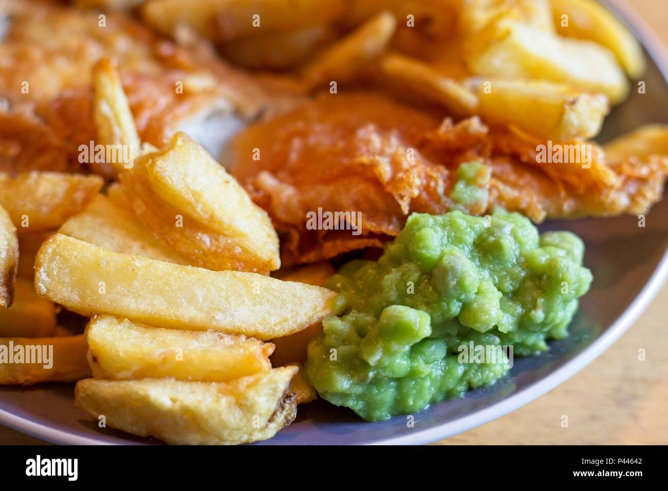 Fish and chips, un repas traditionnel anglais composé de morue frit et frites avec petits pois Banque D'Images