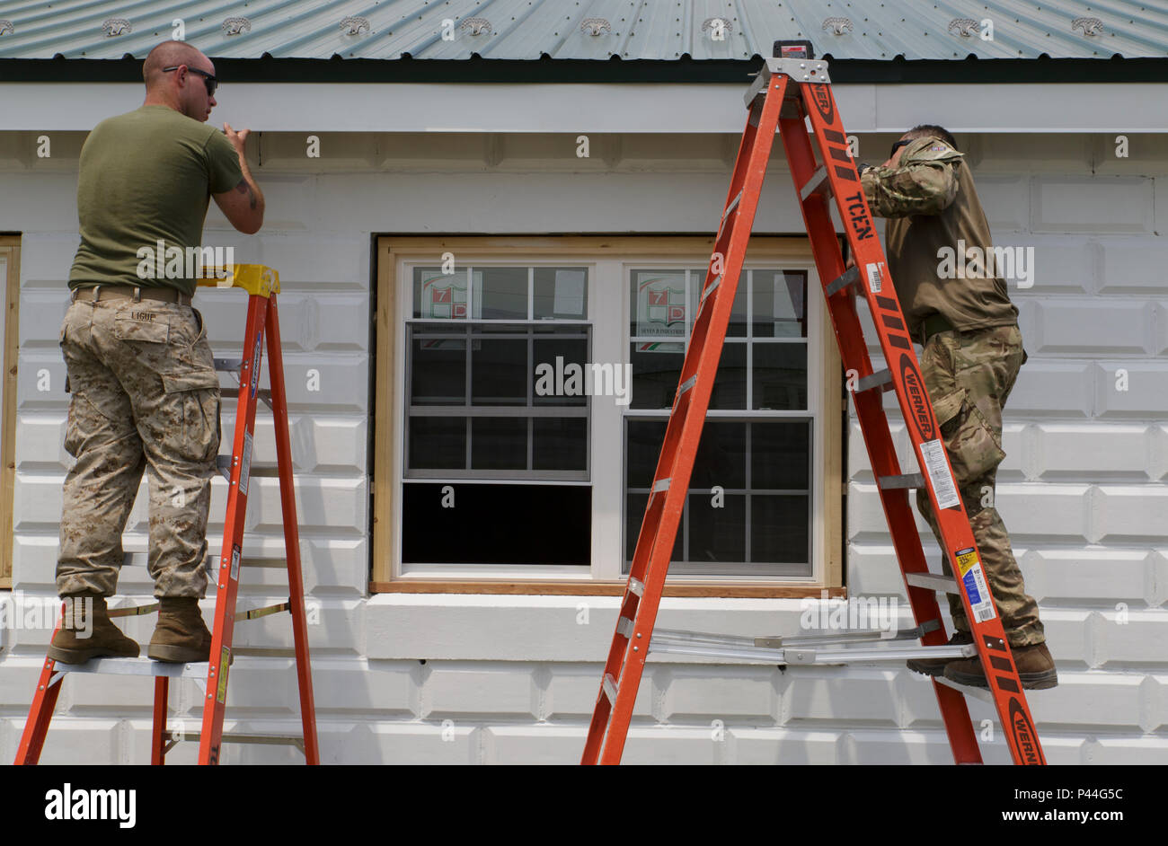 Lance le Cpl. Michael J. Ligue (à gauche), ingénieur de combat avec l'entreprise C, 6e, 4e Bataillon d'appui du Groupe de la logistique maritime, Réserve des Forces maritimes, et Pvt. Antonio Comparetto (à droite), un sapeur avec 131 Escadron Commando des Royal Engineers, l'armée britannique, place sur une garniture de fascia d'aluminium Projet de rénovation de la caserne au cours de l'exercice Red Dagger à Fort Indiantown Gap, Penn., 11 juin 2016. Dans le cadre de l'exercice, les Marines et les commandos britanniques a travaillé sur divers projets de rénovation et de construction autour de la base de l'armée. L'exercice Red poignard est un exercice d'entraînement bilatéral qui donne un Marines Banque D'Images