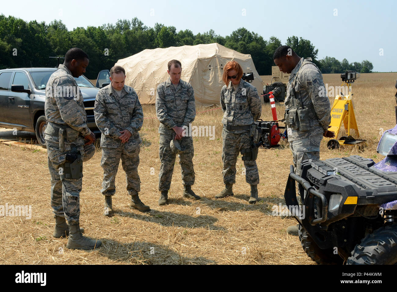 U.S. Air Force 1er Lieutenant Matthew Gray, un aumônier à la 169e Escadre de chasse à la base de la Garde nationale mixte Guess, S.C., prie avec aviateurs, affecté à la 78e Escadron des Forces de sécurité à l'entrée du point de contrôle mis en place à proximité d'un F-16 Fighting Falcon de chasse de l'écrasement à Louisville, Kentucky, le 12 juin 2016. Deux F-16 à partir de la Caroline du Sud Air National Guard mid-air collision lors des activités courantes de formation au vol de nuit dans la région du comté de Jefferson, le 7 juin 2016. Les deux pilotes s'éjecter. (U.S. Air National Guard photo par le Sgt. Caycee Watson) Banque D'Images
