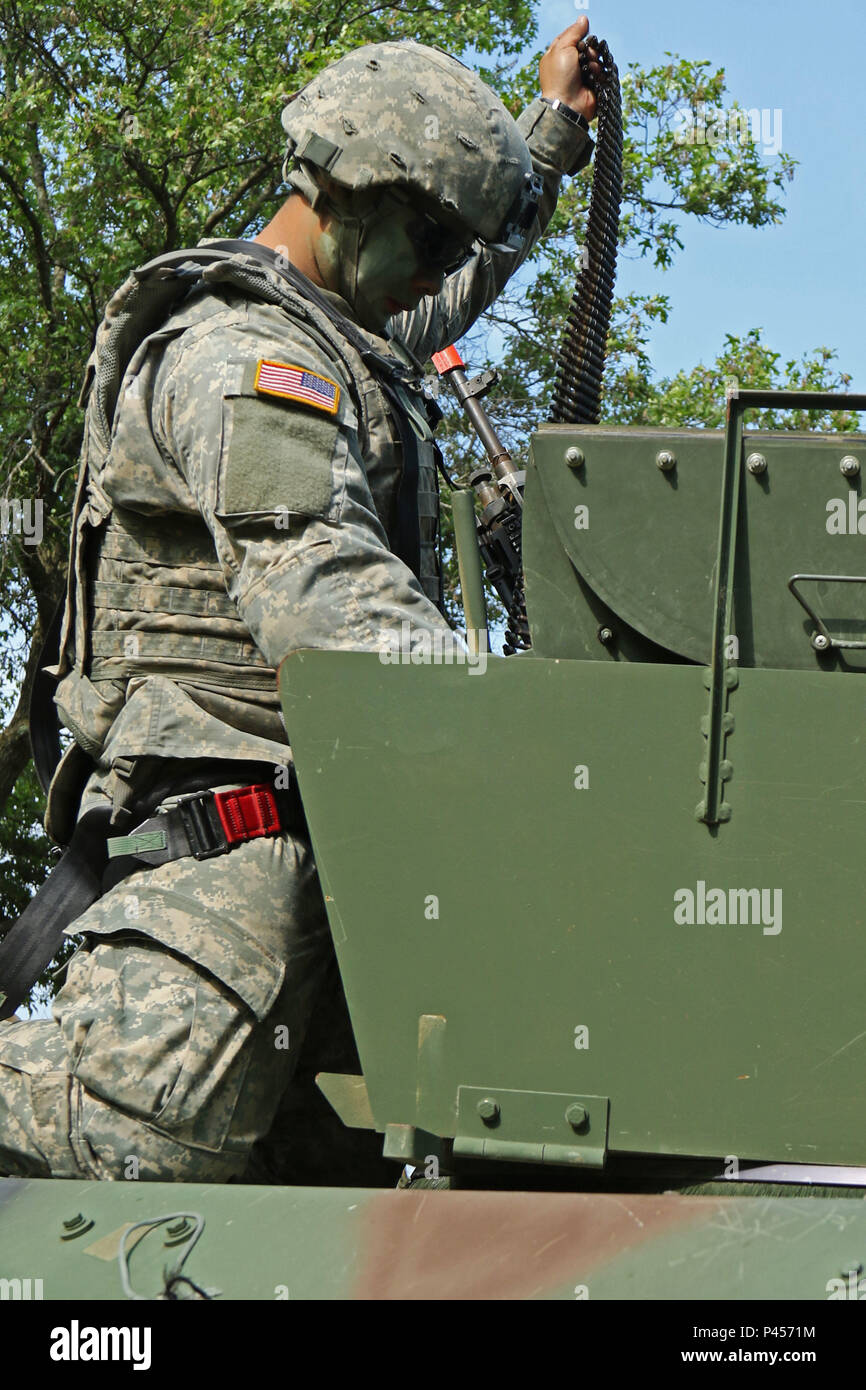 La CPS. Chong Vang, cavalry scout avec 2e Peloton, Troop B, 1er escadron, 105e de cavalerie, d'infanterie 32e Brigade Combat Team, charges 7,62 mm rondes vierge pour un M240B machine gun en préparation d'un itinéraire de formation dans le cadre de la mission de reconnaissance de la formation annuelle de Fort McCoy, au Wisconsin, le 14 juin. (112e Détachement des affaires publiques mobiles photo de la CPS. Kati Stacy/libérés) Banque D'Images