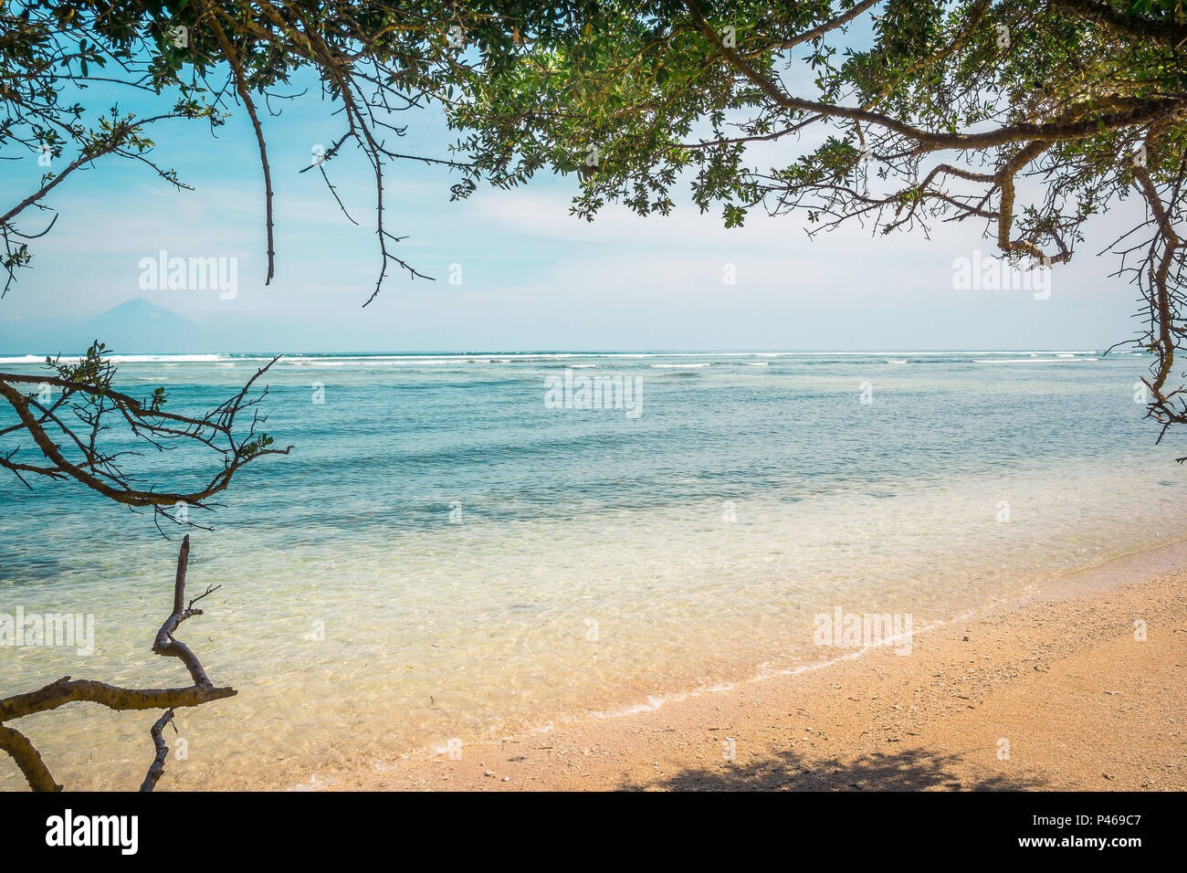 Une plage tropicale avec de l'eau claire comme du cristal dans un cadre d'arbres et le volcan de Bali dans l'arrière-plan, Gili Trawangan, Indonésie, le 25 avril, 2018 Banque D'Images
