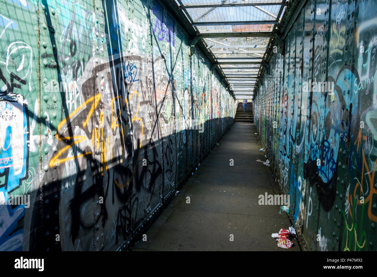 Personne dans la distance proche passerelle pour piétons avec chaque mur recouvert de graffitis et de déchets sur le terrain, Sheffield, England, UK Banque D'Images