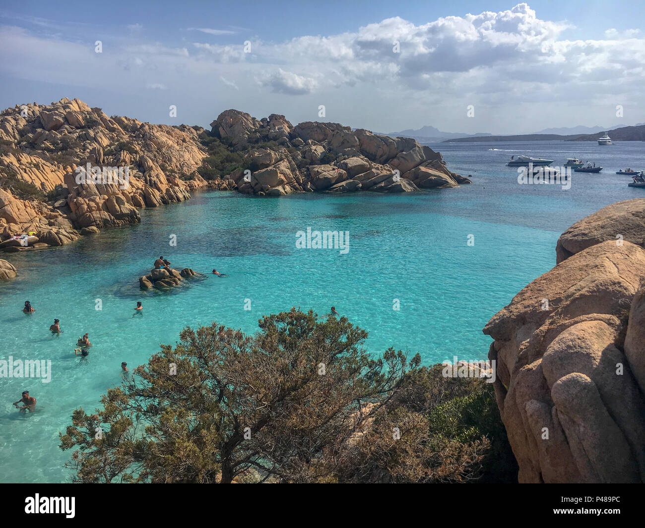 Caprera, Italie - septembre 8, 2017 : la vie à la plage avec des gens assis sur des pierres à Spiaggia Cala Coticcio sur l'île italienne de Caprera Banque D'Images