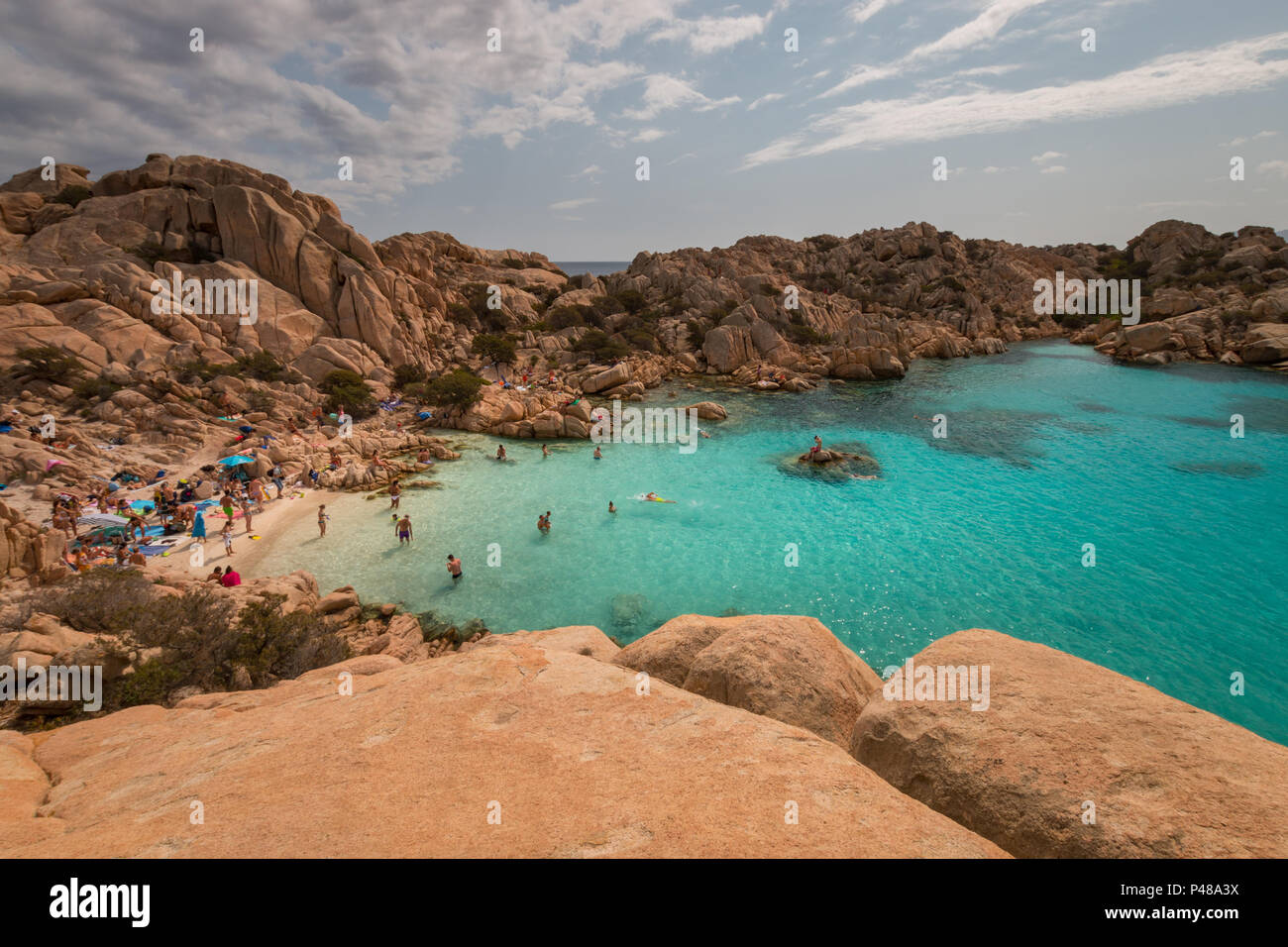 Caprera, Italie - septembre 8, 2017 : la vie à la plage avec des gens assis sur des pierres à Spiaggia Cala Coticcio sur l'île italienne de Caprera Banque D'Images