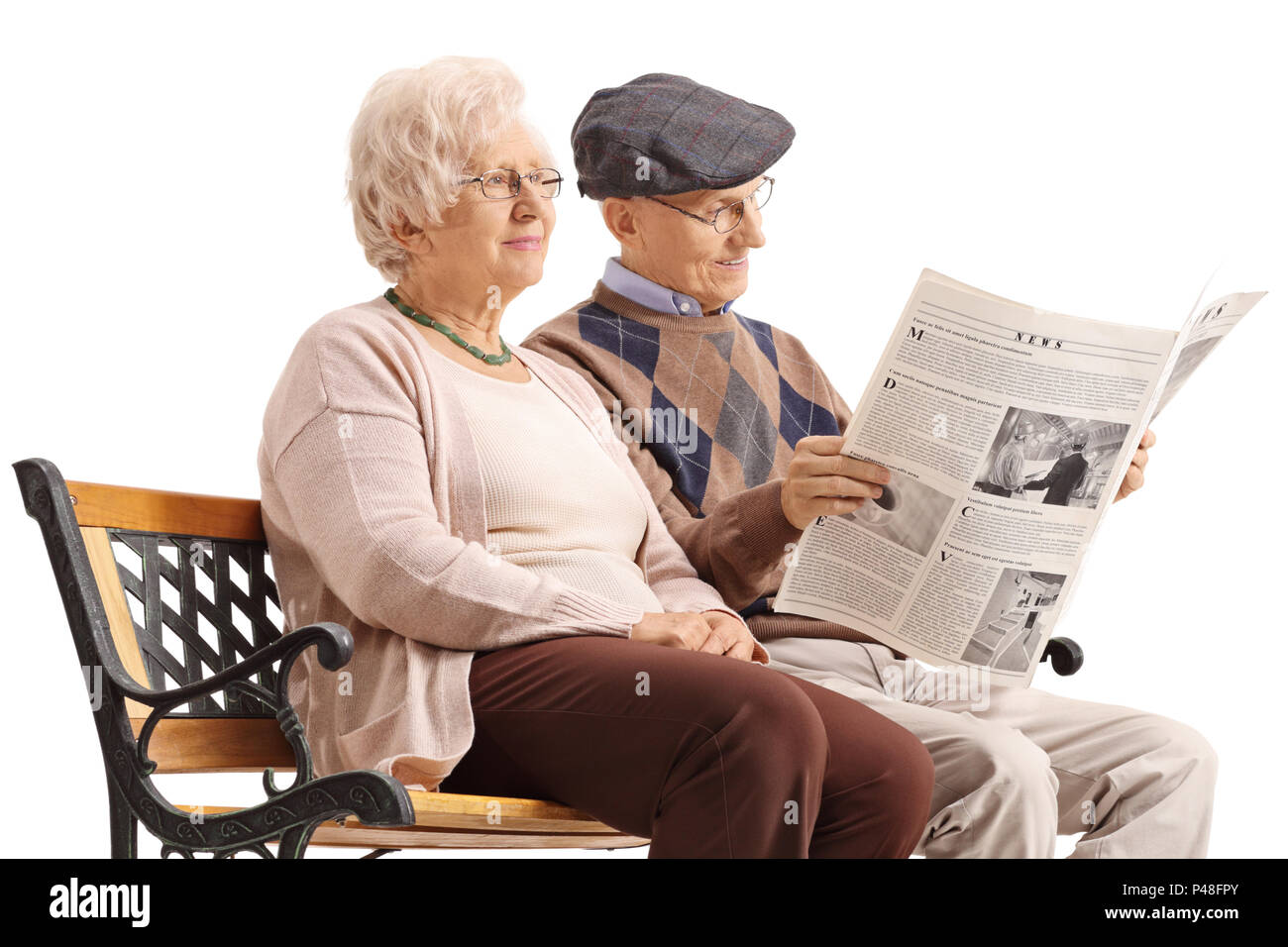 Les personnes âgées assises sur un banc et lire un journal isolé sur fond blanc Banque D'Images