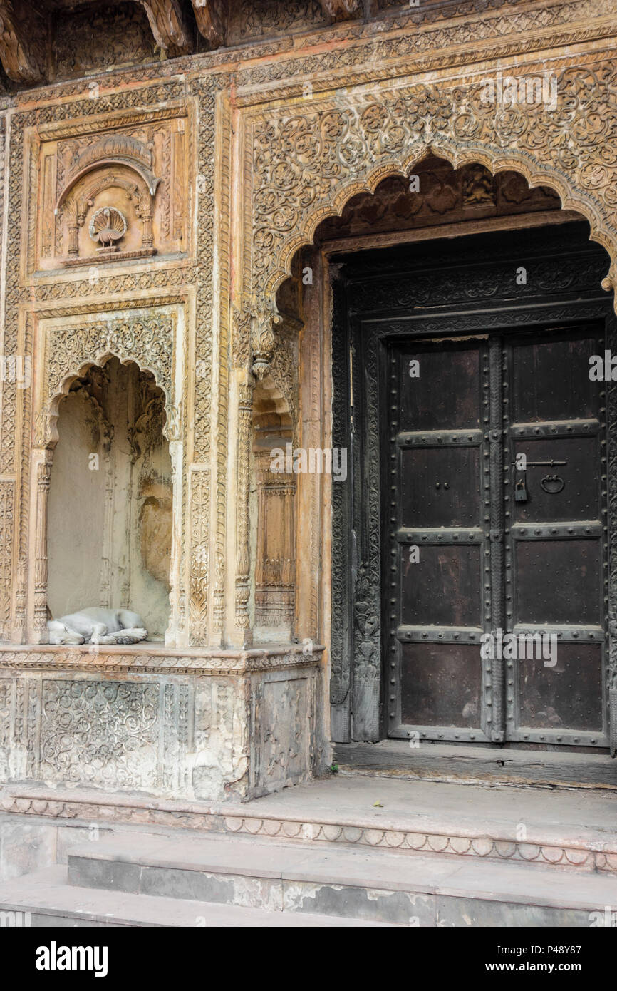 Détail d'une pièce d'une porte d'un haveli ou hôtel particulier typique du Rajasthan avec un chien dans l'alcôve, National Crafts Museum, New Delhi, Inde Banque D'Images