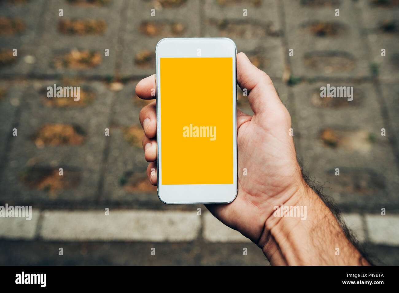 La main avec la maquette du smartphone copie espace, l'homme à l'aide de téléphone mobile contemporain moderne dans la rue en milieu urbain Banque D'Images