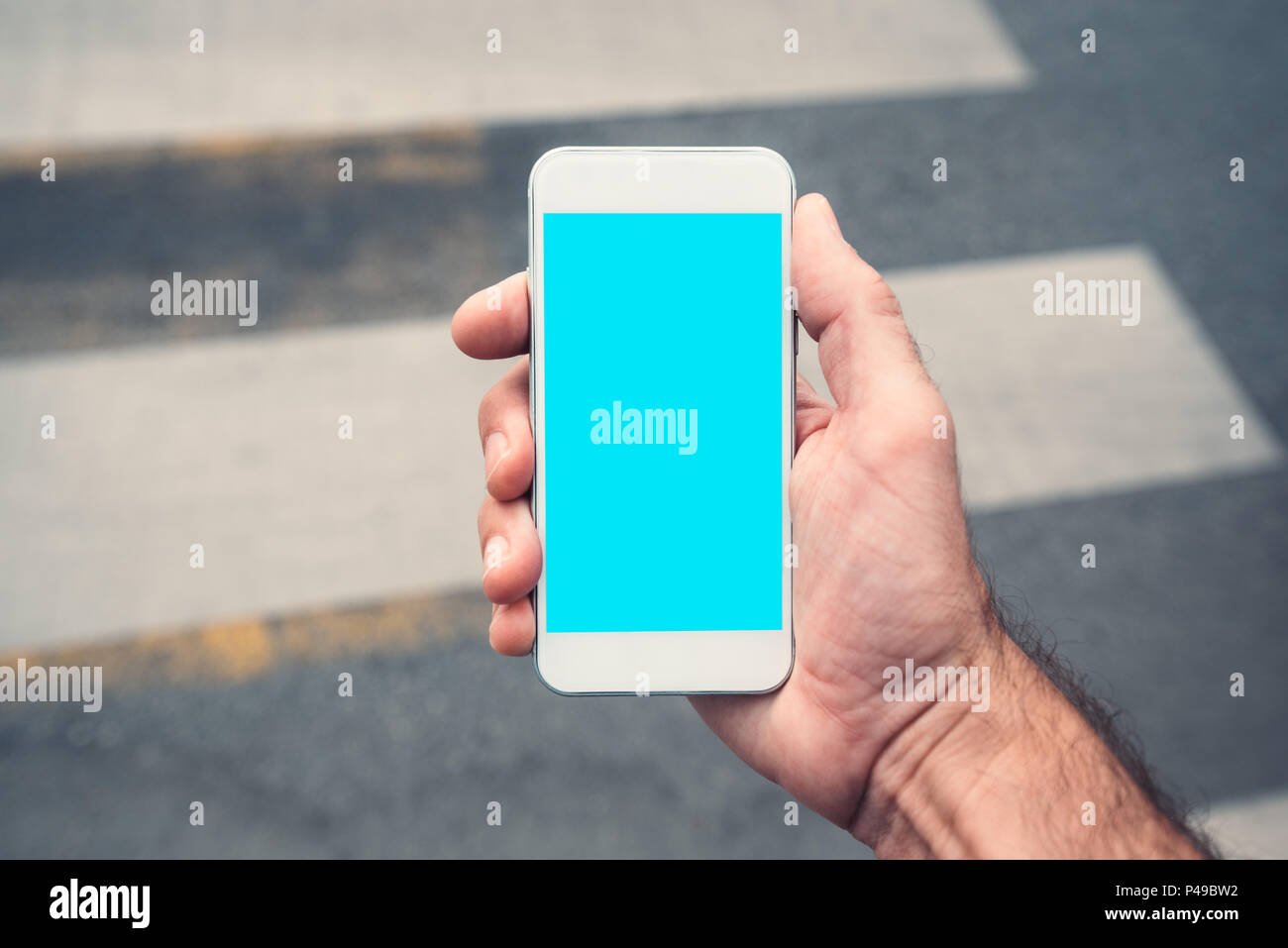 La main avec la maquette du smartphone copie espace, l'homme à l'aide de téléphone mobile contemporain moderne dans la rue en milieu urbain Banque D'Images