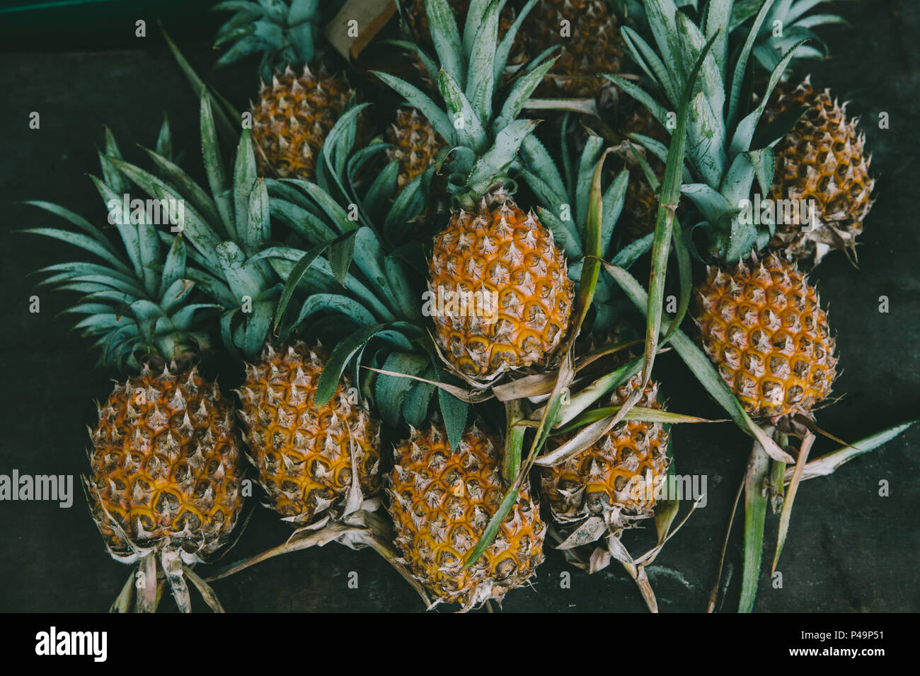 L'ananas sur fond de table en bois noir vintage art la nuance de couleur. Banque D'Images
