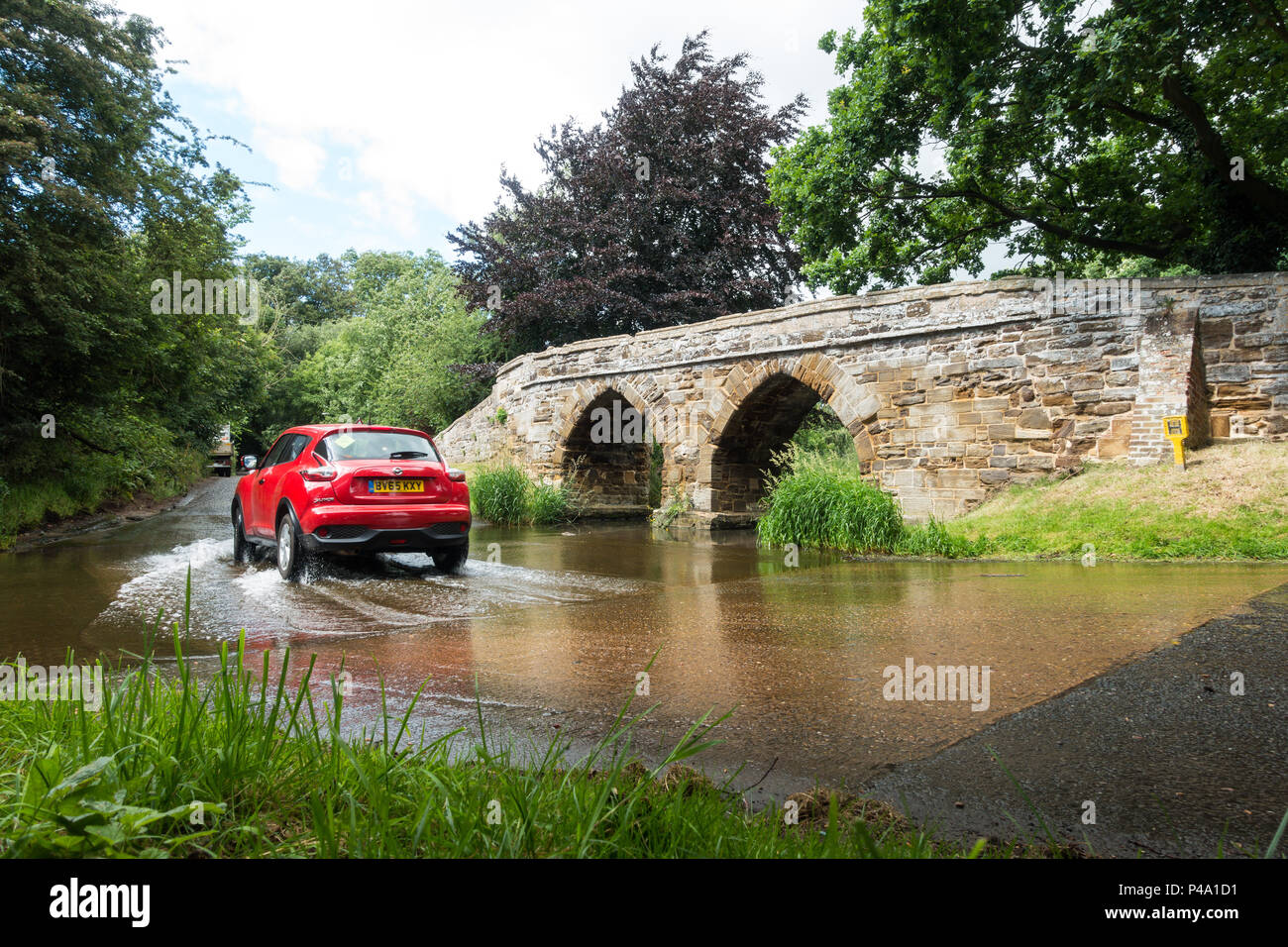 Une passerelle en pierre sur une Ford dans un village typiquement anglais en été. Sutton, Bedfordshire Banque D'Images