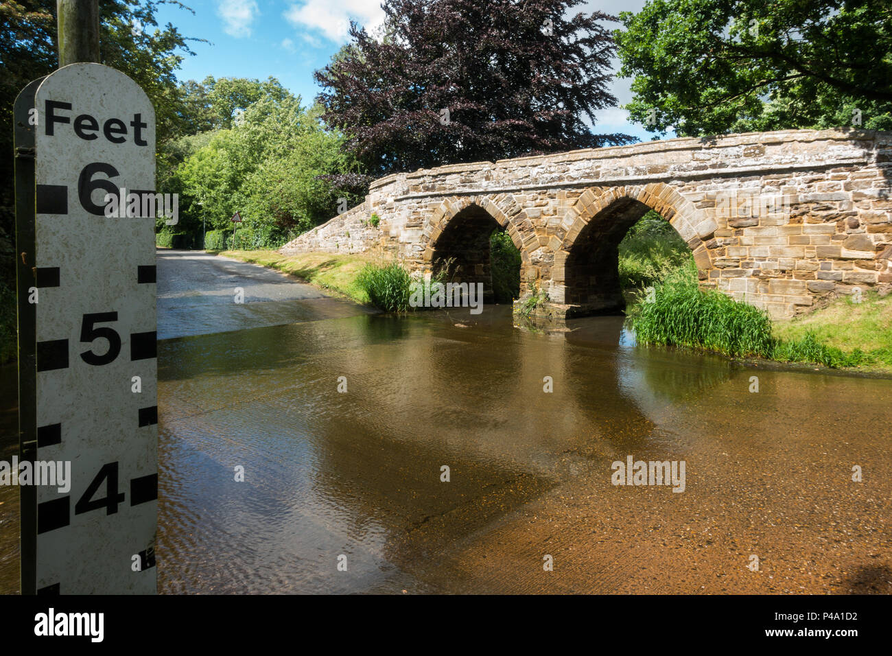 Une passerelle en pierre sur une Ford dans un village typiquement anglais en été. Sutton, Bedfordshire Banque D'Images