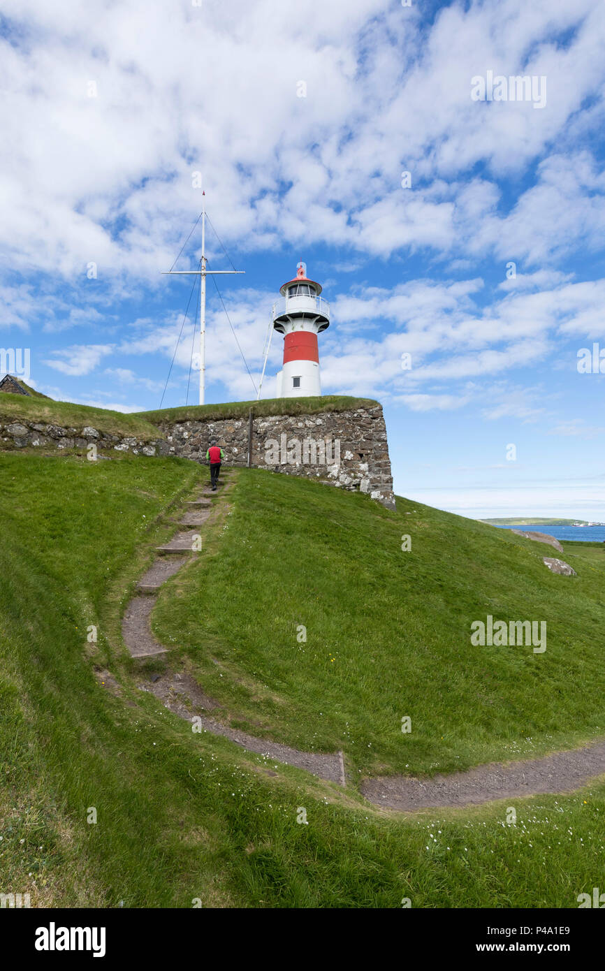 Homme marche au phare et forteresse historique de Capitole, Torshavn, Streymoy Island, Îles Féroé Banque D'Images