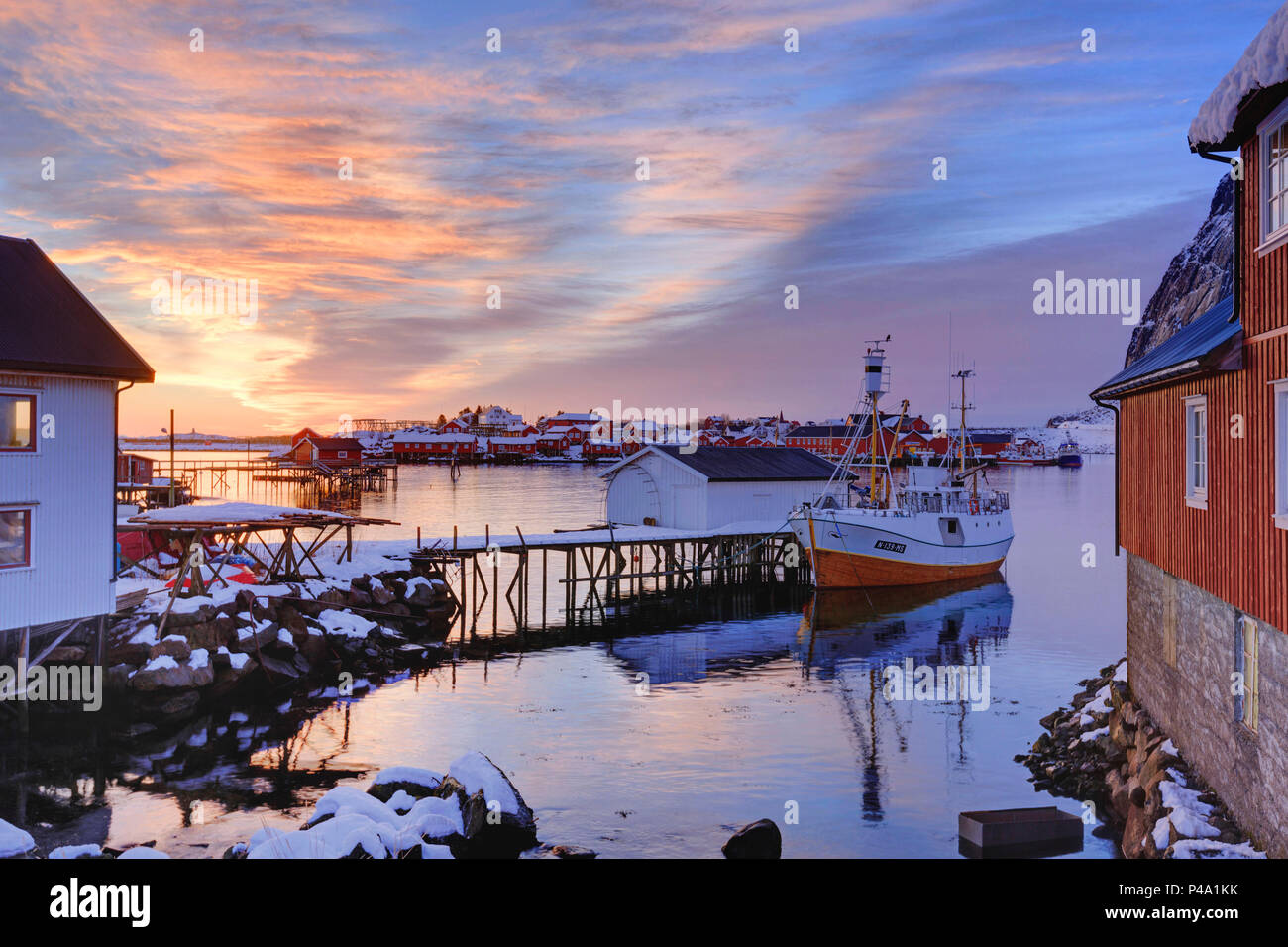 Un petit bateau de pêche au quai de pêche Reine au lever du soleil en hiver, îles Lofoten, Nordland, Norvège, Europe Banque D'Images