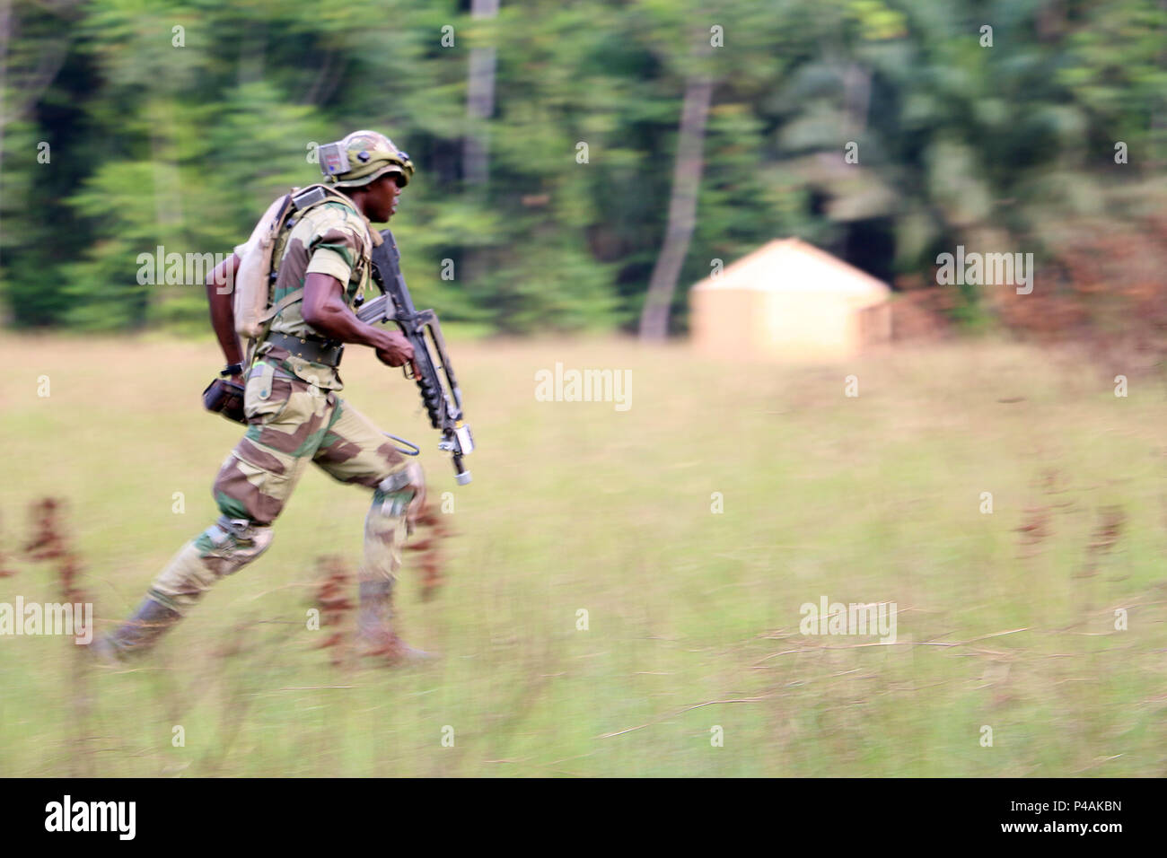 Un soldat des Forces armées Gabon court à travers un champ d'engager un ennemi en contact direct lors d'accord central de 016 terrain à Ayeme, le Gabon, le 23 juin 2016. L'exercice de l'Afrique de l'armée américaine CA 16 est une annuelle, combinés, exercice militaire conjoint qui réunit les nations partenaires pour pratiquer et démontrer sa compétence dans la conduite des opérations de maintien de la paix. (U.S. Photo de l'armée par le sergent. Candace Mundt/libérés) Banque D'Images