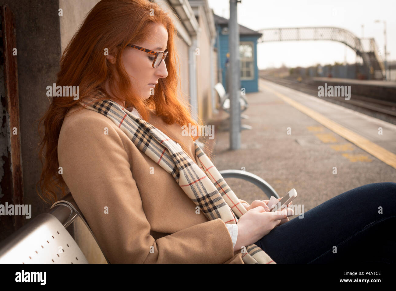 Woman using mobile phone à la gare Banque D'Images
