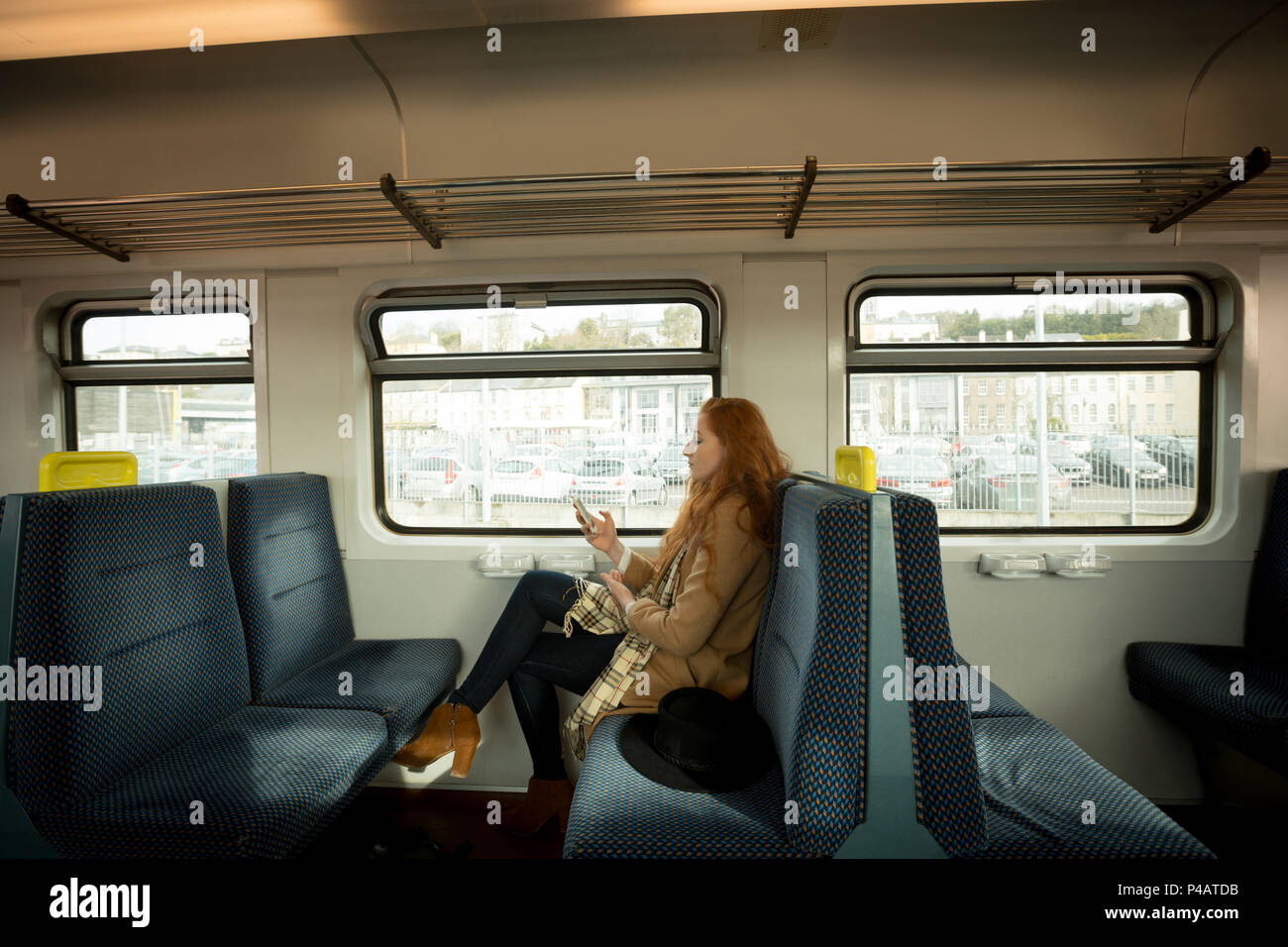 Femme à l'aide de téléphone portable en voyage en train Banque D'Images