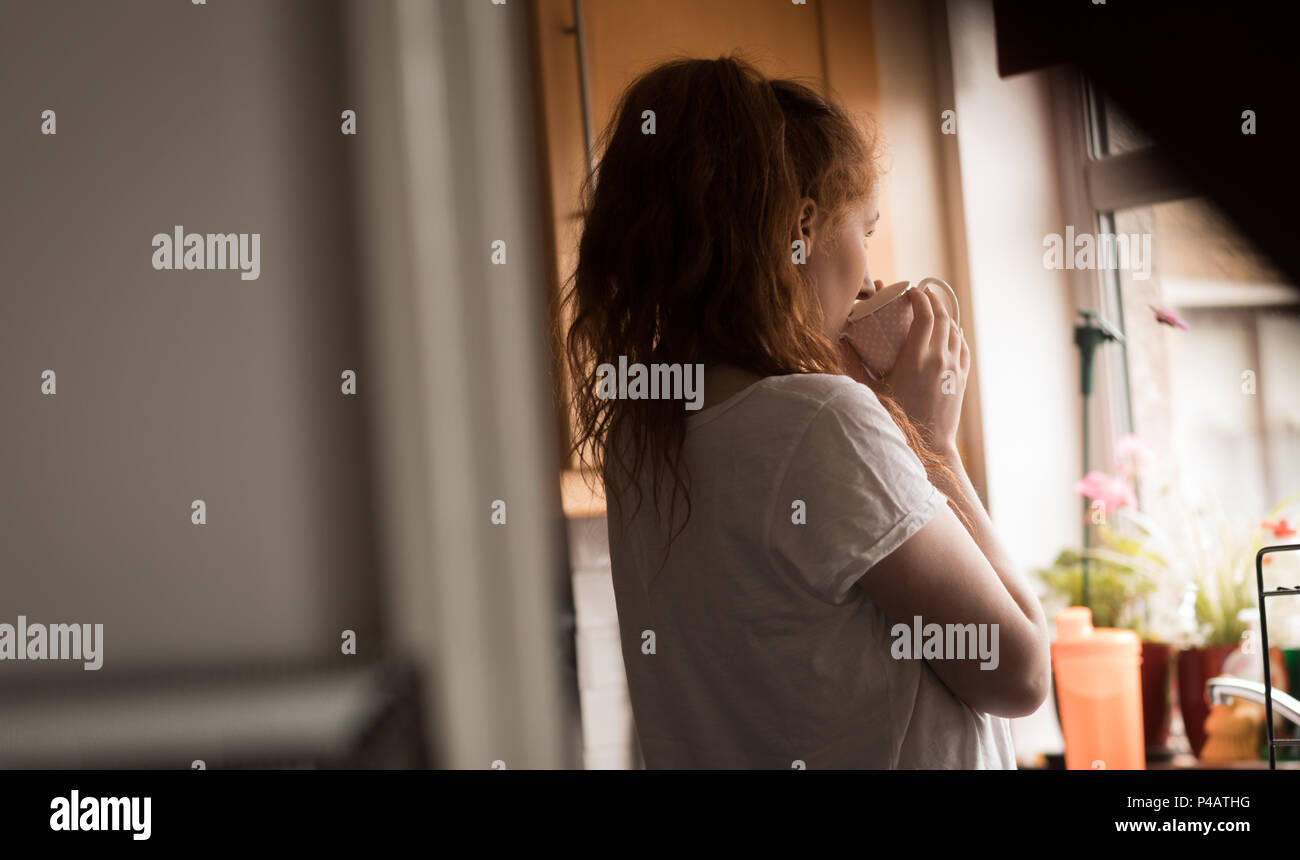 Woman having coffee in cuisine à la maison Banque D'Images