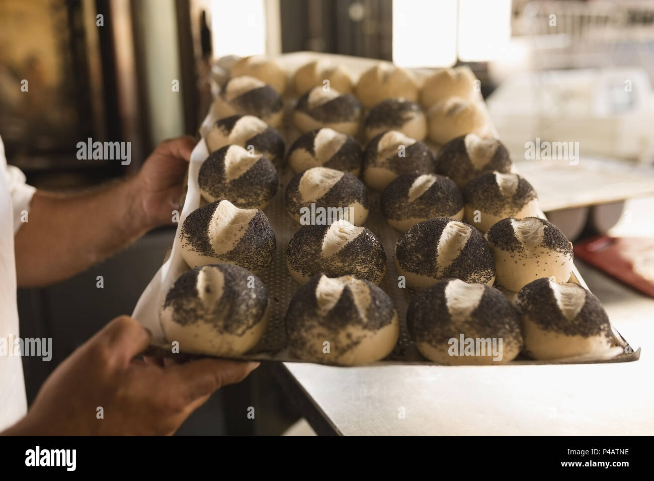Male baker holding tray of round croissants Banque D'Images
