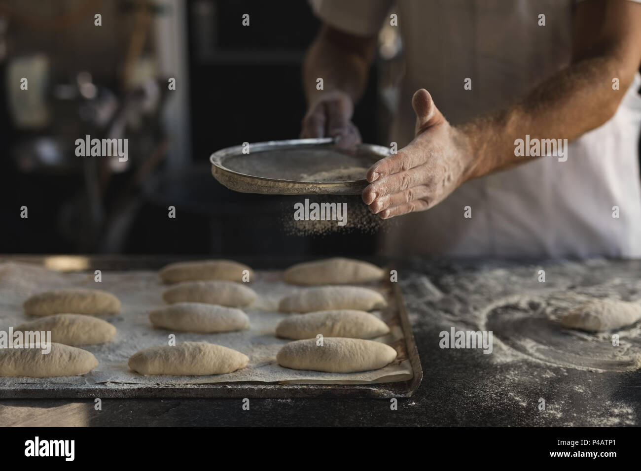 Préparer la pâte en mâle baker bakery shop Banque D'Images