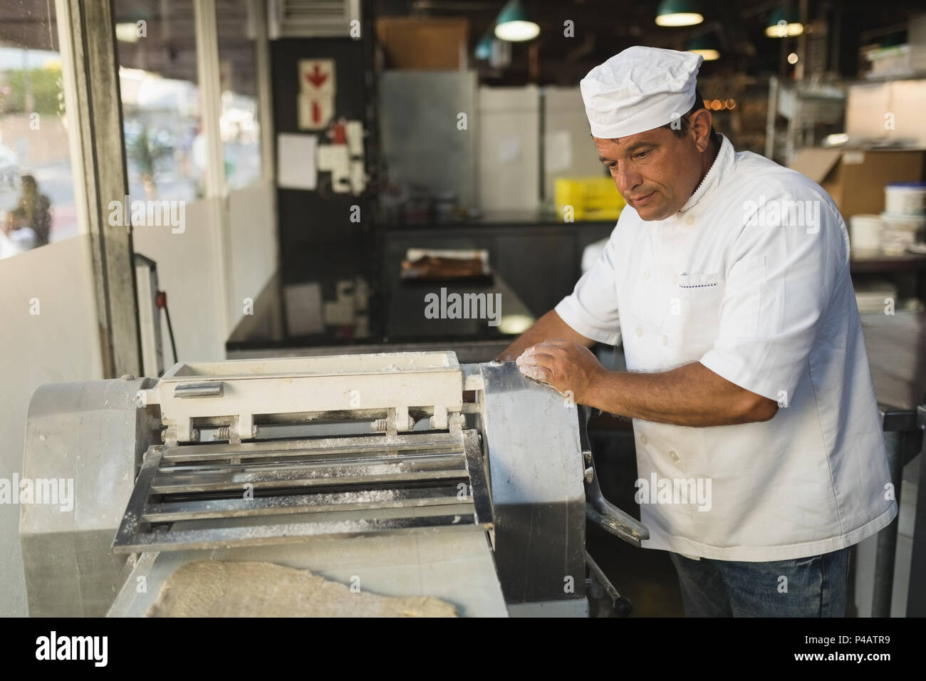 L'utilisation de la machine en mâle baker bakery shop Banque D'Images