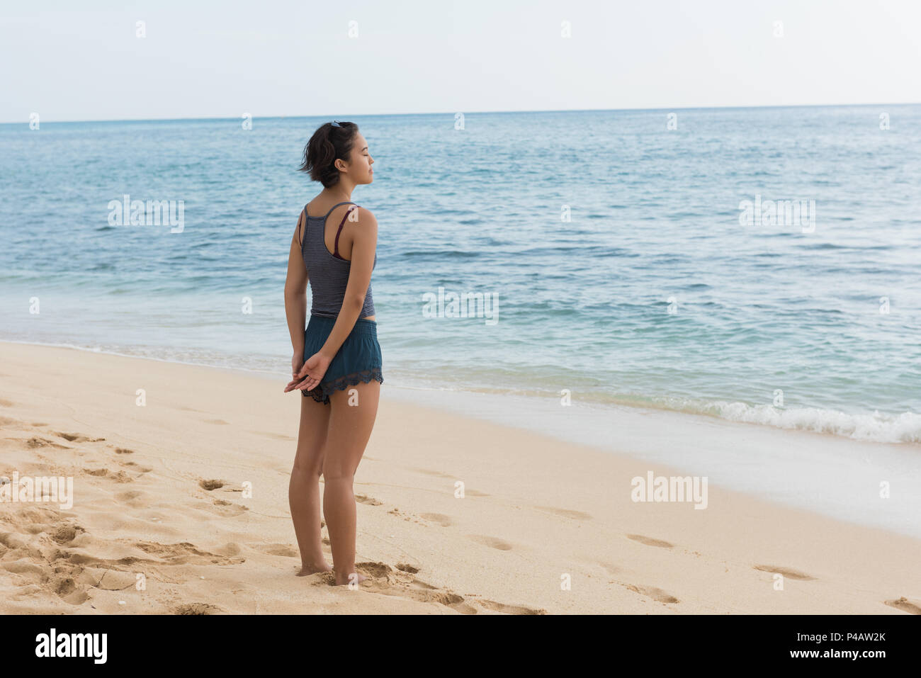 Femme debout avec les yeux fermés dans la plage Banque D'Images