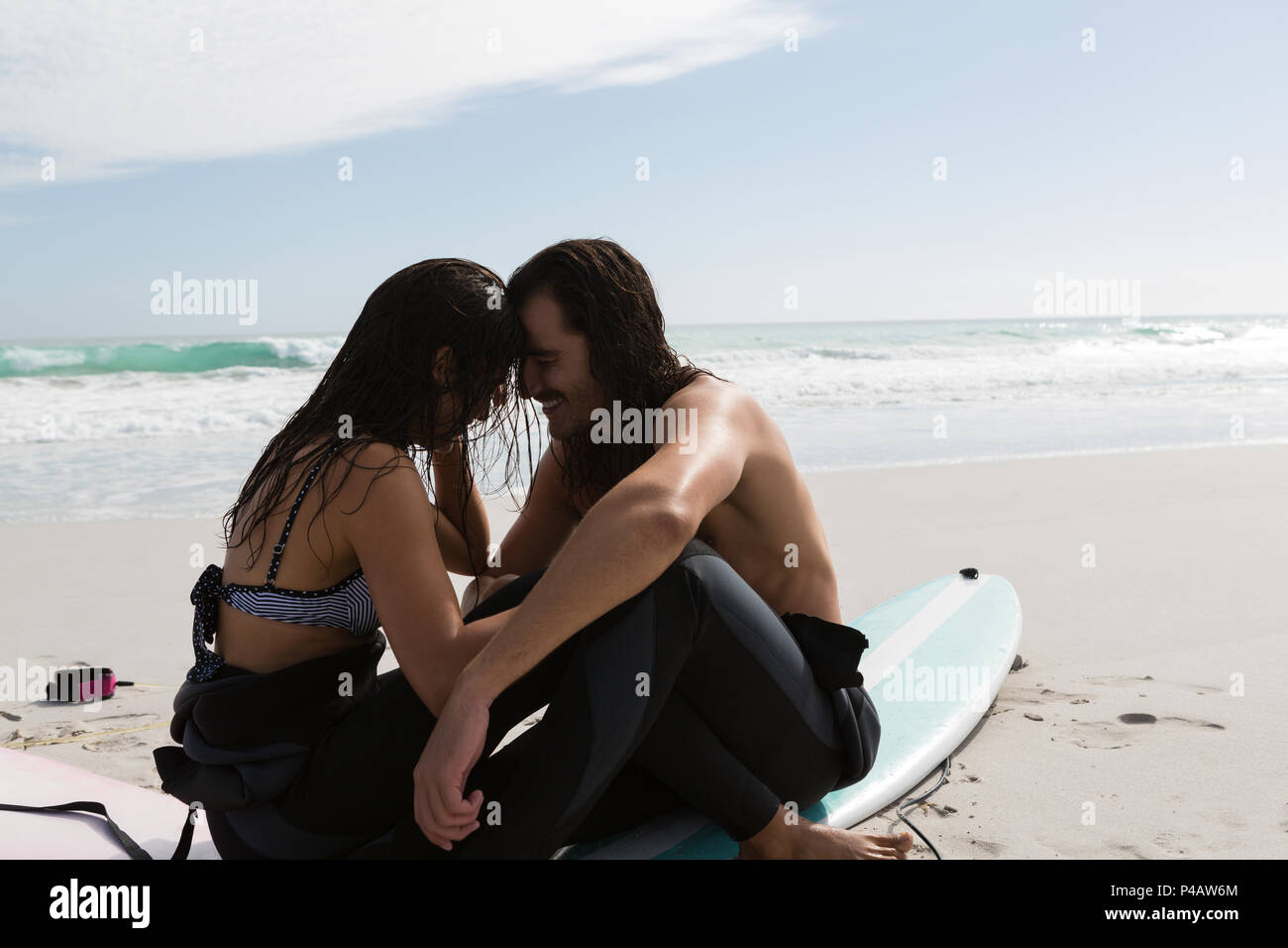 Surfer couple romancing dans la plage Banque D'Images