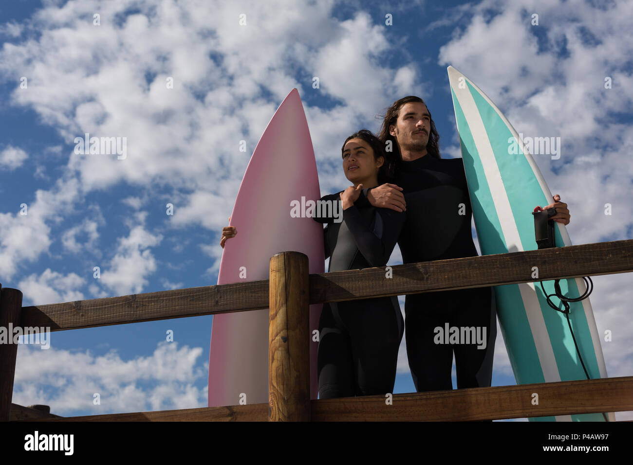Surfer couple standing with surfboard dans la plage Banque D'Images