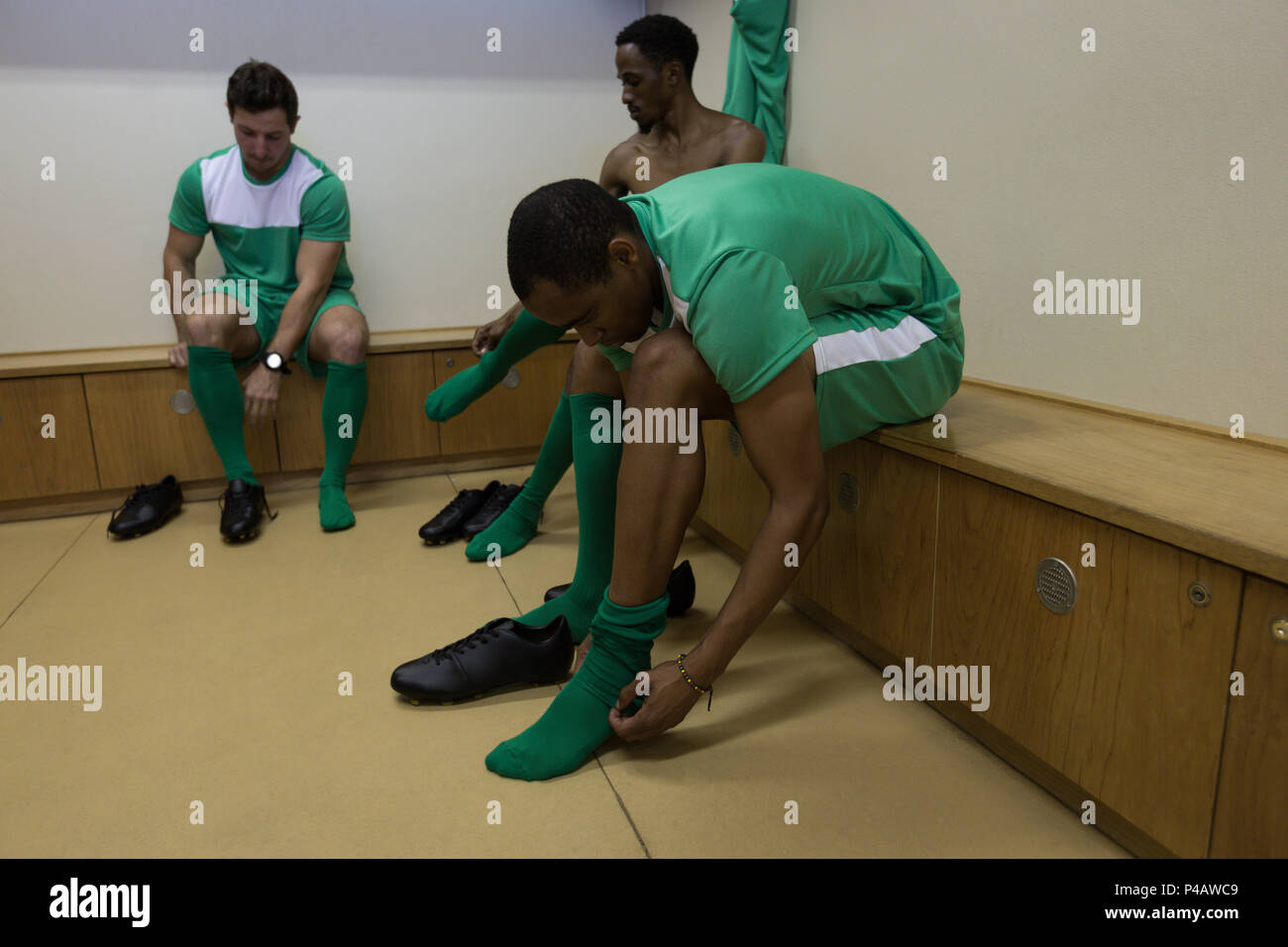 Les joueurs de football de porter des chaussettes dans dressing Banque D'Images