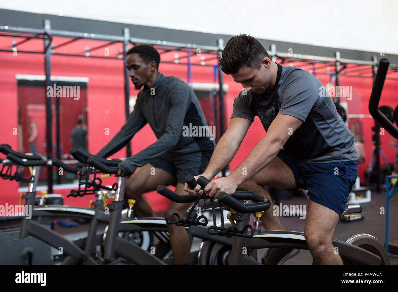 L'exercice des athlètes sur les vélos d'exercice dans une salle de sport Banque D'Images