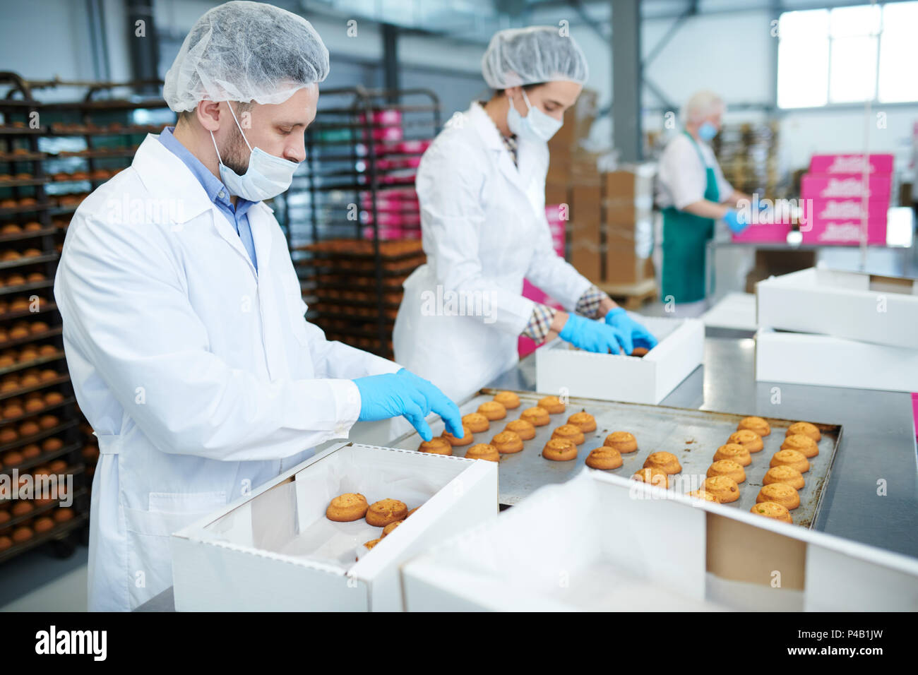 Les travailleurs de l'usine de confiserie pâtisserie mettre dans des boîtes Banque D'Images