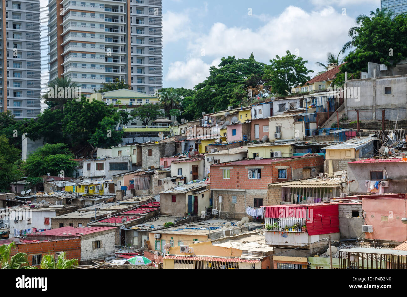 Maisons colorées des habitants pauvres de Luanda, Angola. En arrière-plan les bâtiments élevés des riches Banque D'Images