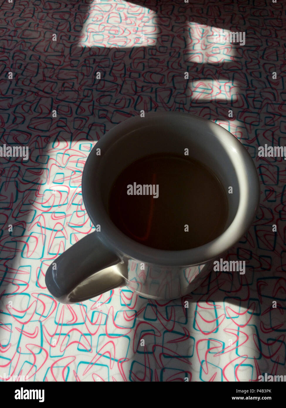 La lumière du soleil tôt le matin jette ombre sur tasse de café assis sur la table de diner, Fargo, Dakota du Nord Banque D'Images