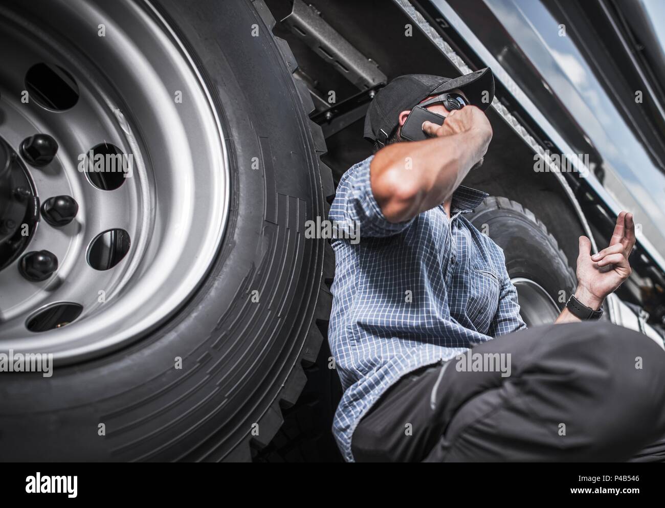 La conduite de camions Concept d'entreprise. Camionneur Caucasienne sur le téléphone à côté de son véhicule. Banque D'Images