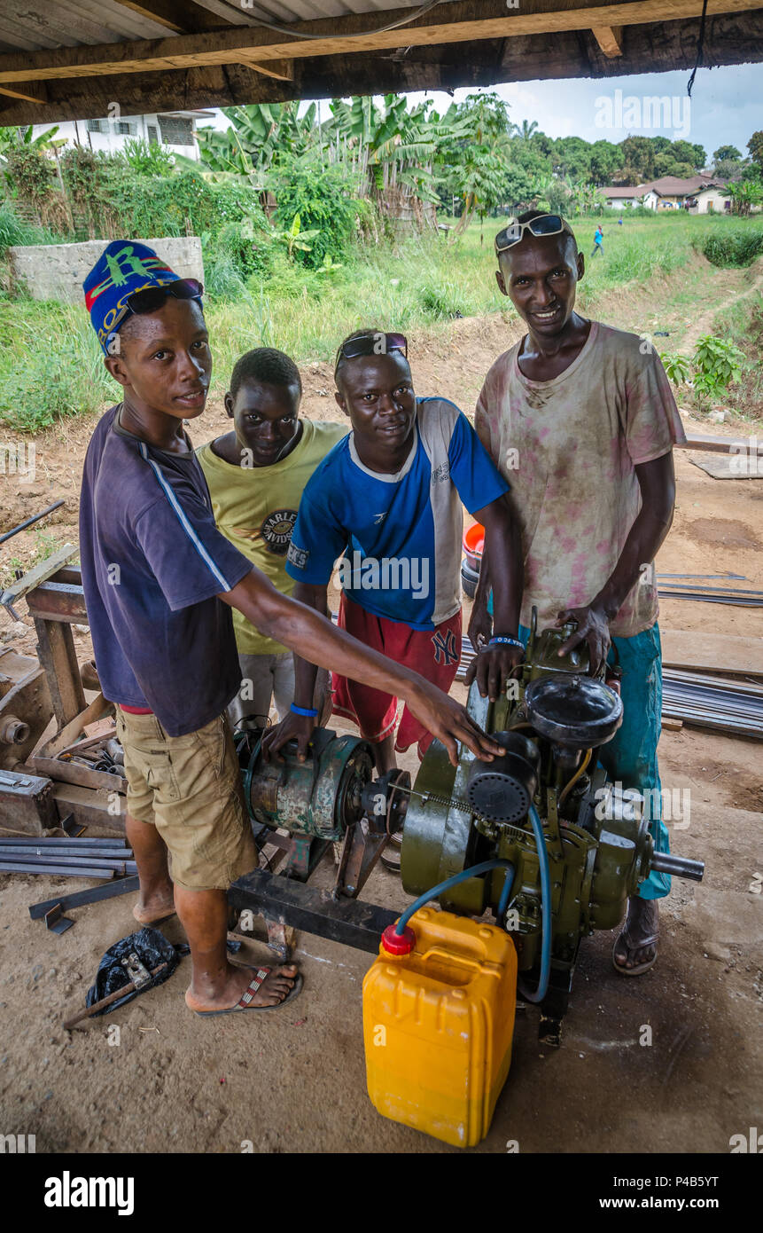 Bo, Sierra Leone - le 19 janvier 2014 : Groupe de jeunes Africains non identifiés d'exploitation mécanique générateur diesel pour faire fonctionner les machines Banque D'Images