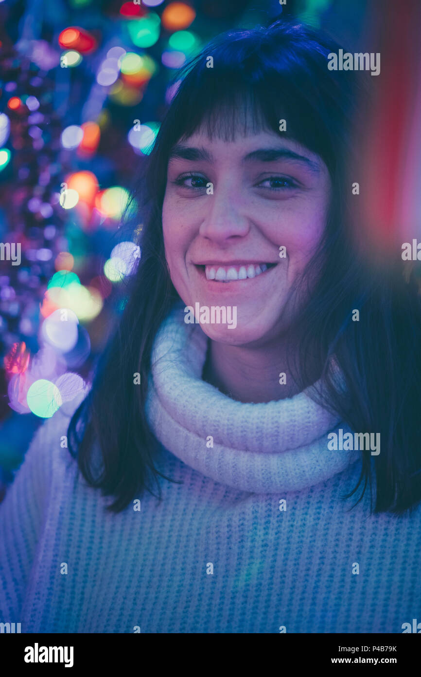 Brunette woman face au milieu de quelques lumières de Noël Banque D'Images