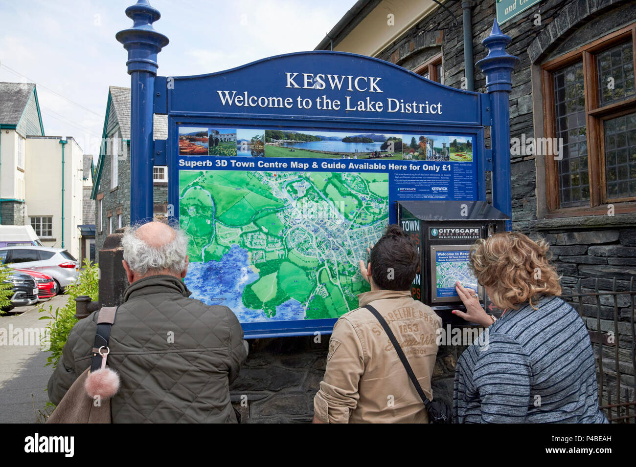 Les touristes étrangers l'examen d'une carte de la ville de Keswick Cumbria Lake District Angleterre UK Banque D'Images