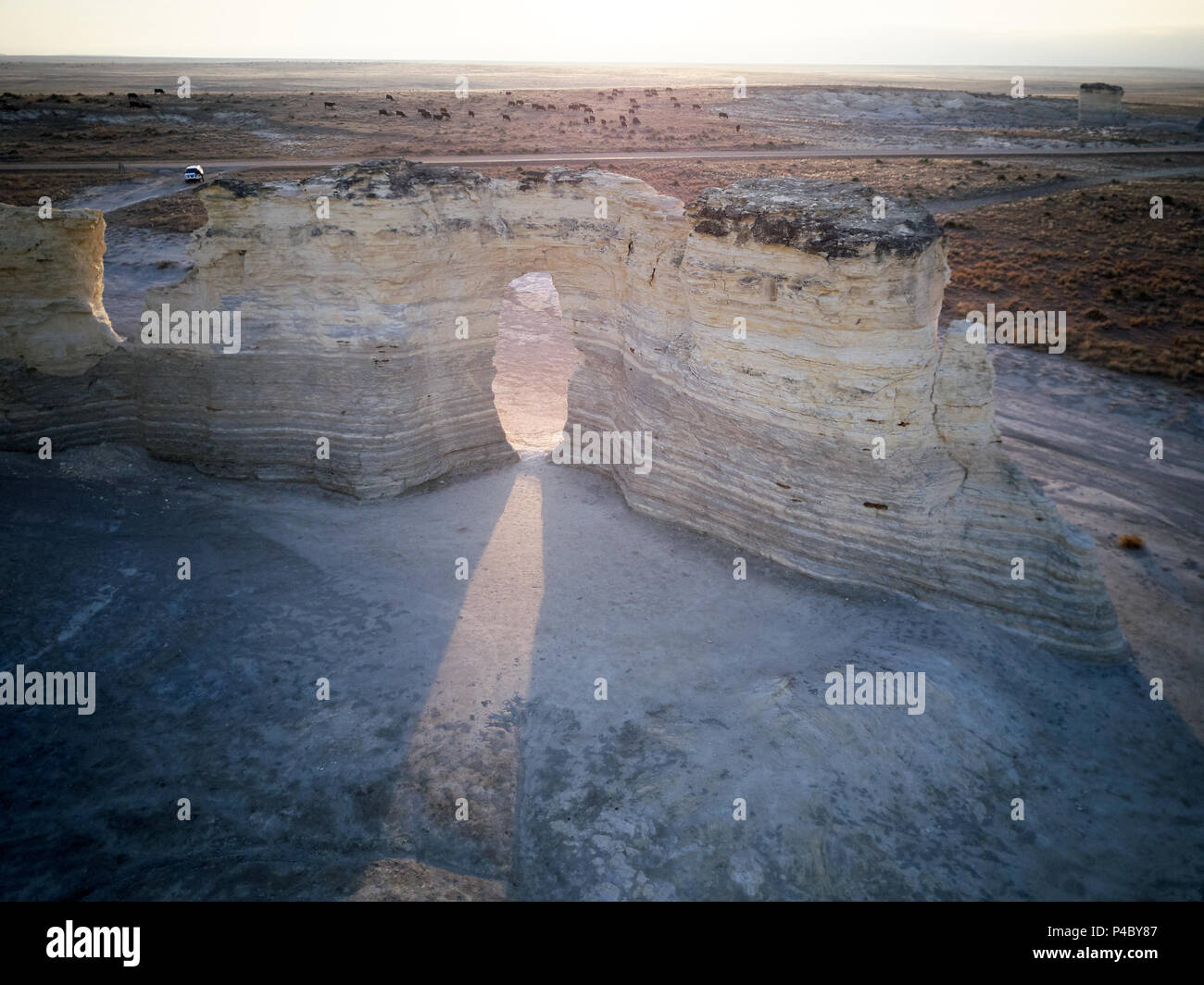 Faisceau de lumière brillant à travers une arche naturelle dans les pyramides de craie à Monument Rocks, Kansas au lever ou au coucher du soleil Banque D'Images