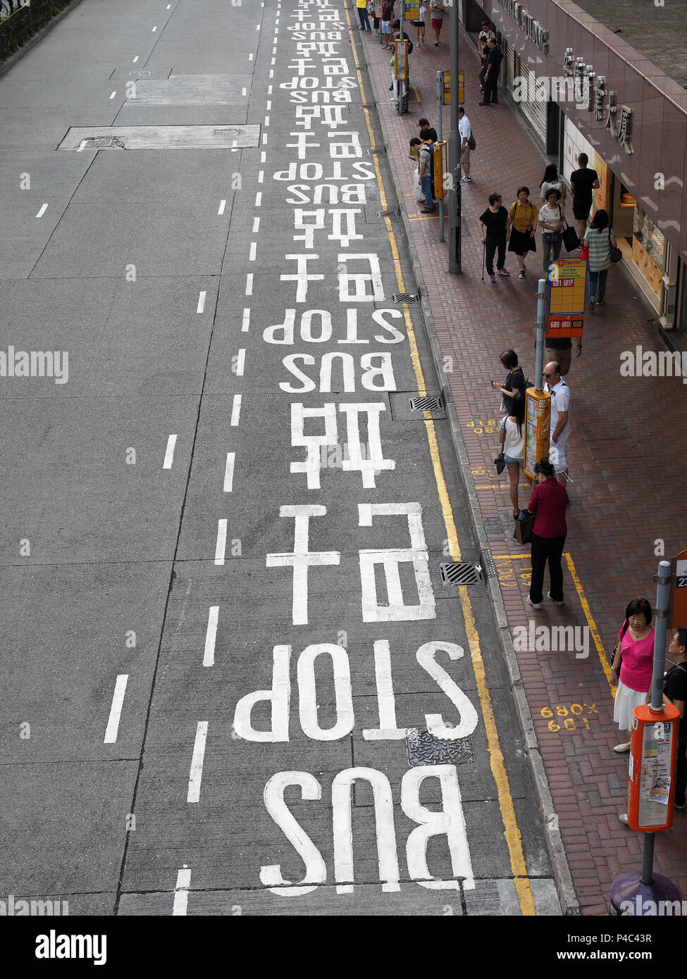 Vue d'un long couloir de bus avec une signalisation en anglais et en chinois à Hong Kong Banque D'Images