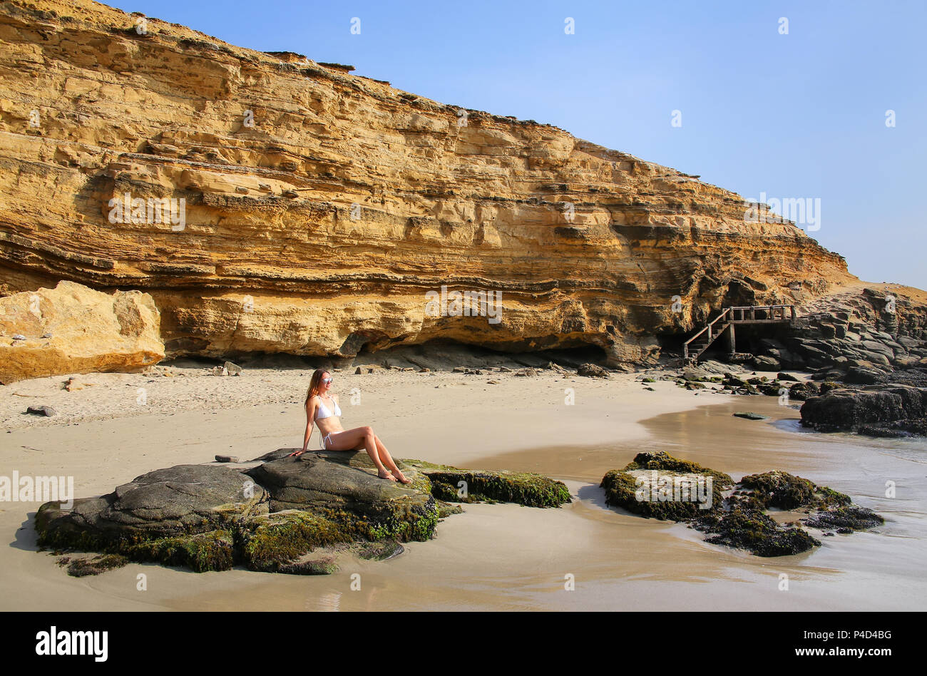 Young woman in bikini assis à La Mina Beach dans la réserve nationale de Paracas, au Pérou. Objectif principal de la réserve est de protéger l'écosystème marin et histo Banque D'Images