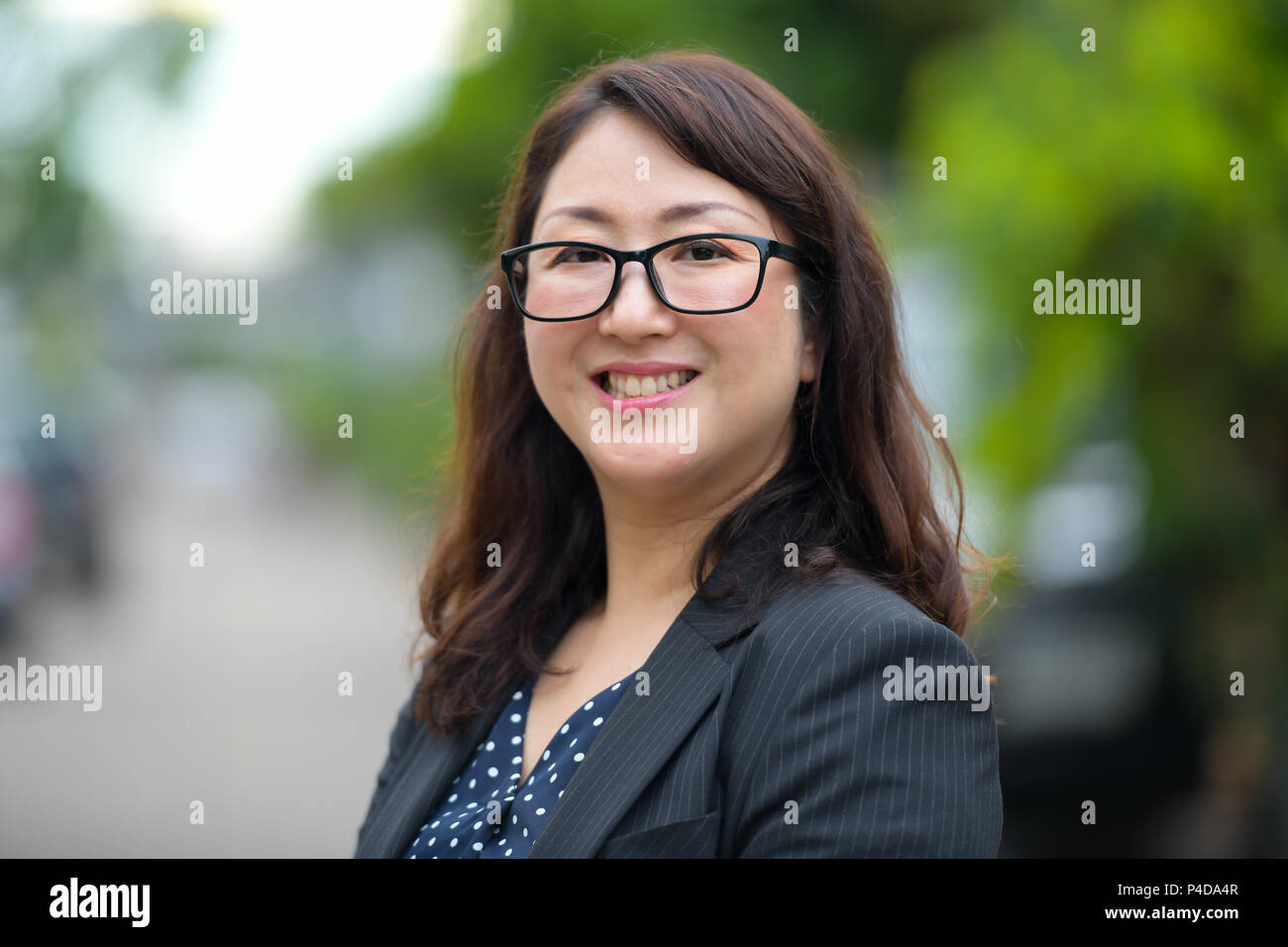 Happy mature Asian businesswoman smiling dans les rues à l'extérieur Banque D'Images