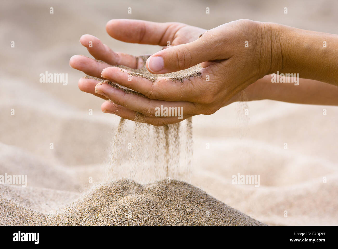 Le sable qui traverse les doigts de la femme dans la plage Banque D'Images