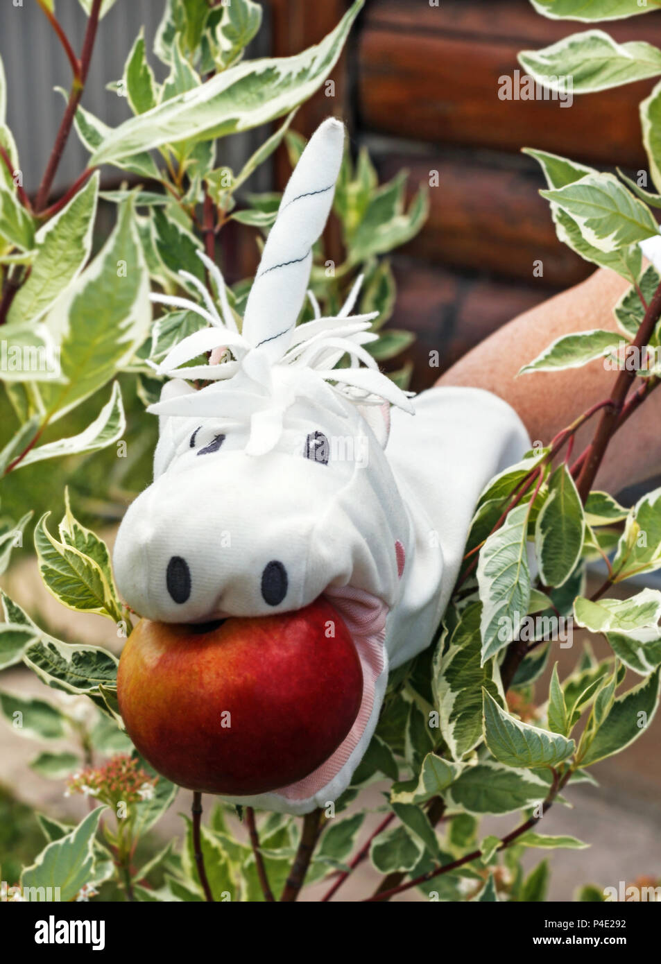 Jouet blanc sur la main avec apple unicorn Banque D'Images