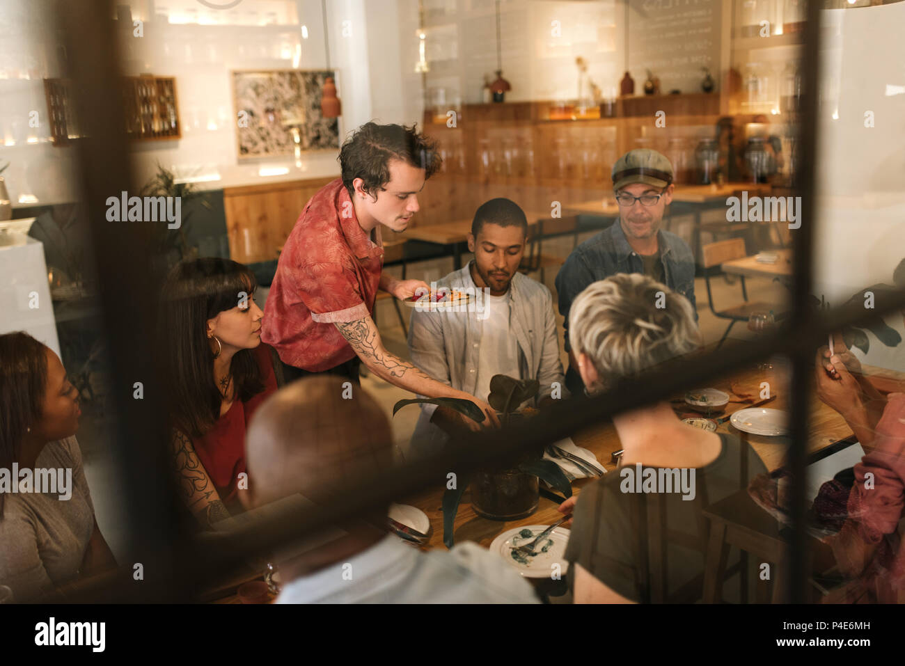 Waiter serving food aux clients à l'intérieur d'un bistro branché Banque D'Images