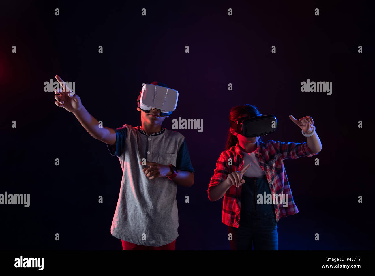 Fille sérieuse et un garçon portant des casques VR Banque D'Images