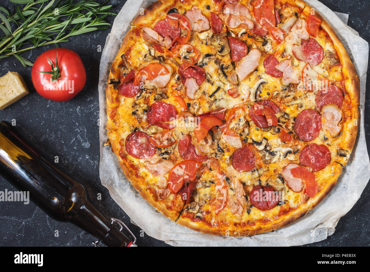 Des pizzas fraîches avec pepperoni, jambon, fromage et une bouteille de